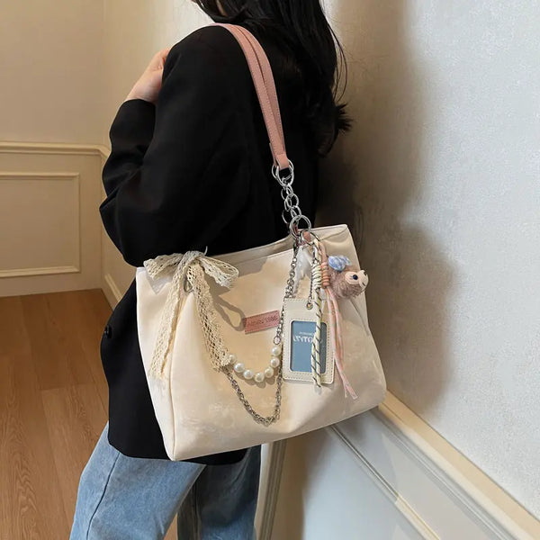 On-model cream canvas shoulder tote with beaded strap and patches, back view in hallway.