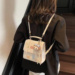 On-model cream patchwork mini backpack with chain straps, three-quarter back view indoors.