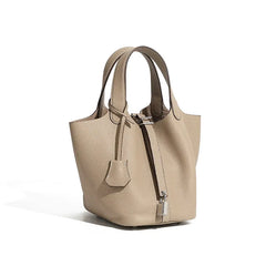 Classic Leather Bucket Bag in soft neutral tone with top-handle and drawstring, showcasing minimalist everyday style.