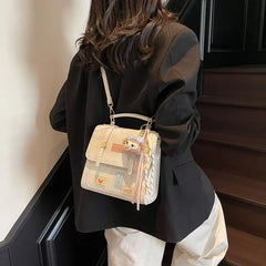 On-model cream patchwork mini backpack with chain straps, front view against wall.