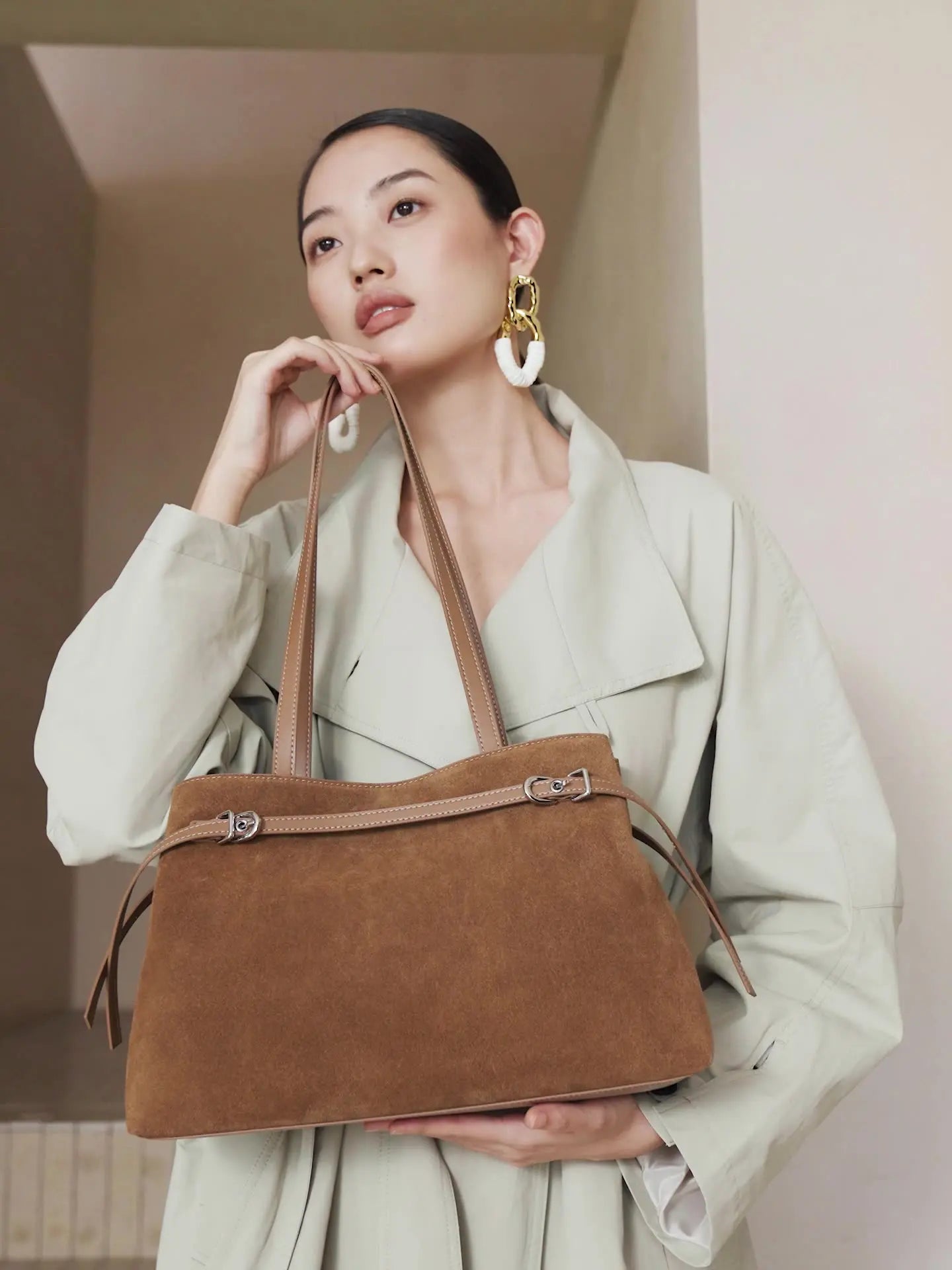 Fashion model showcasing a Suede Leather Baguette Shoulder Bag in brown, featuring a minimalist design and versatile style.