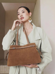 Fashion model showcasing a Suede Leather Baguette Shoulder Bag in brown, featuring a minimalist design and versatile style.