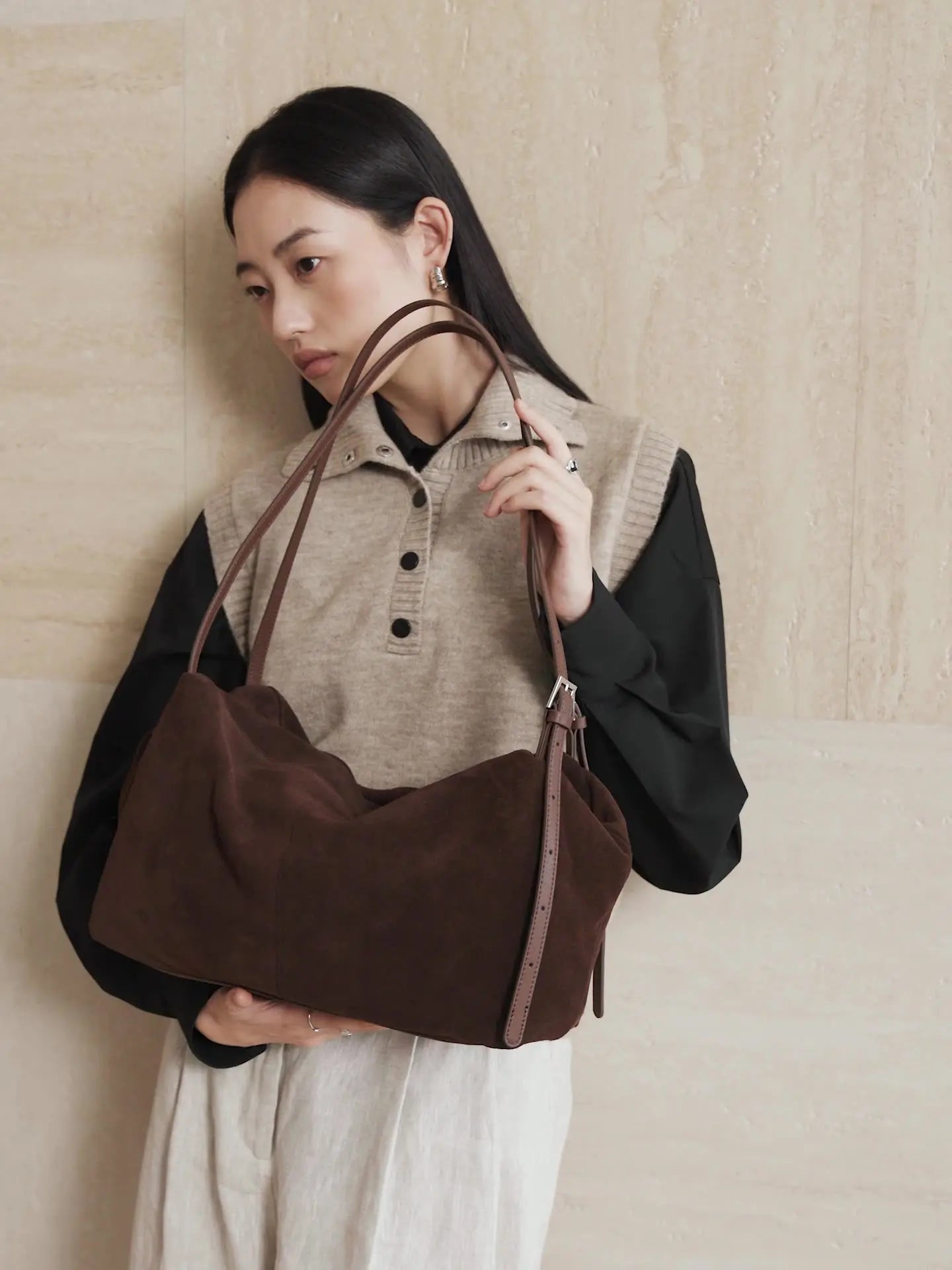 Suede Leather Pillow Hobo Bag in brown worn casually by a woman, showcasing its stylish design and dual straps.