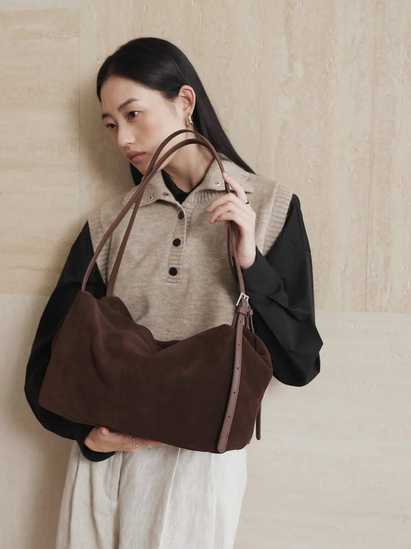 Suede Leather Pillow Hobo Bag in brown worn casually by a woman, showcasing its stylish design and dual straps.