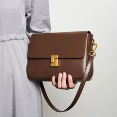 Minimalist Tofu Bag in brown leather with a magnetic closure and adjustable strap, suitable for everyday use.