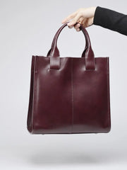 Top-Handle Leather Tote held by hand, lightweight and compact for everyday use, perfect for work or casual outings.