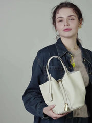 Classic Leather Bucket Bag styled in a minimalist studio shot, featuring a neutral tone and drawstring detail.