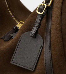 Suede Crescent Shoulder Bag close-up showing leather tag detail, showcasing its vintage-inspired design and quality.