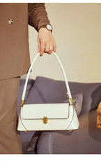European Retro Shoulder Bag held in hand, featuring a minimalist white design and a stylish chain strap.