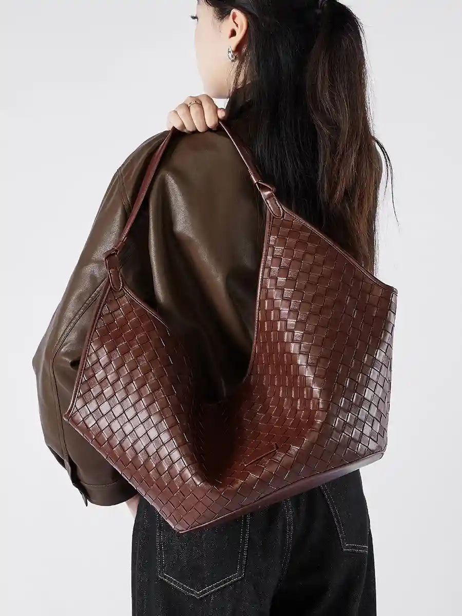 Large Woven Shoulder Bag in brown leather with woven texture, carried by a woman, showcasing a chic, vintage-inspired style.