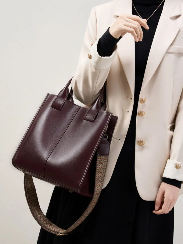 Top-Handle Leather Tote with adjustable strap displayed by model in stylish outfit.