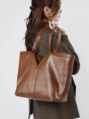 Large Leather Tote Bag shown from the side, highlighting its sleek design and natural texture.