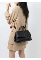 Woman wearing a Premium Leather Crossbody Bag in black, styled in a chic casual outfit with a modern urban look.