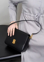Minimalist Tofu Bag worn as a crossbody bag, featuring genuine leather, magnetic closure, and adjustable strap in black.