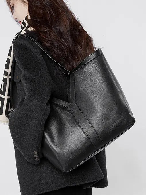 Large Leather Tote Bag in black, stylishly worn as a shoulder bag, ideal for everyday use, lightweight and minimalist design.