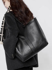 Large Leather Tote Bag in black, stylishly worn as a shoulder bag, ideal for everyday use, lightweight and minimalist design.