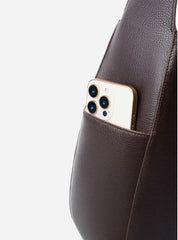 Leather Crescent Hobo Bag showing a smartphone in the open pocket, showcasing its practical design and functionality.