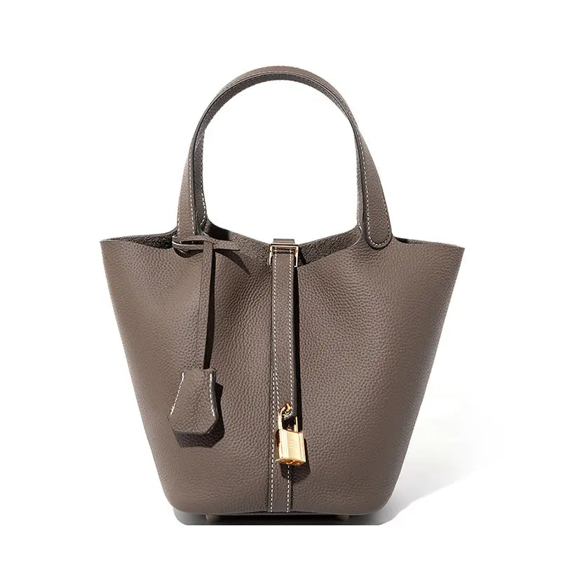 Classic Leather Bucket Bag in neutral tone with minimalist design, showcasing top-handle and drawstring features.