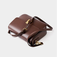 Minimalist Tofu Bag in brown leather with adjustable strap and gold hardware, perfect for everyday use.