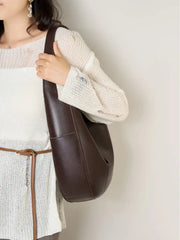 Leather Crescent Hobo Bag in brown worn as a shoulder bag with a casual outfit, showcasing its stylish design.