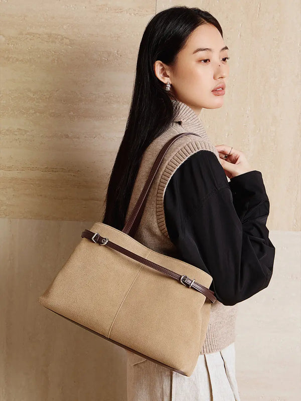 Suede Leather Baguette Shoulder Bag in beige carried by a model, showcasing its minimalist design and versatility.