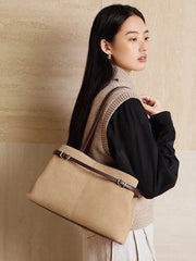 Suede Leather Baguette Shoulder Bag in beige carried by a model, showcasing its minimalist design and versatility.