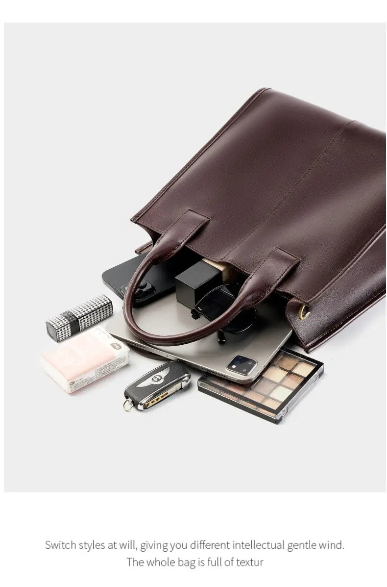 Top-Handle Leather Tote with accessories like laptop, makeup, and wallet on a clean surface.
