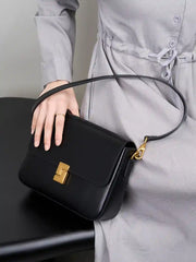 Minimalist Tofu Bag in black leather with a gold clasp and adjustable strap, perfect for everyday or date-night styling.