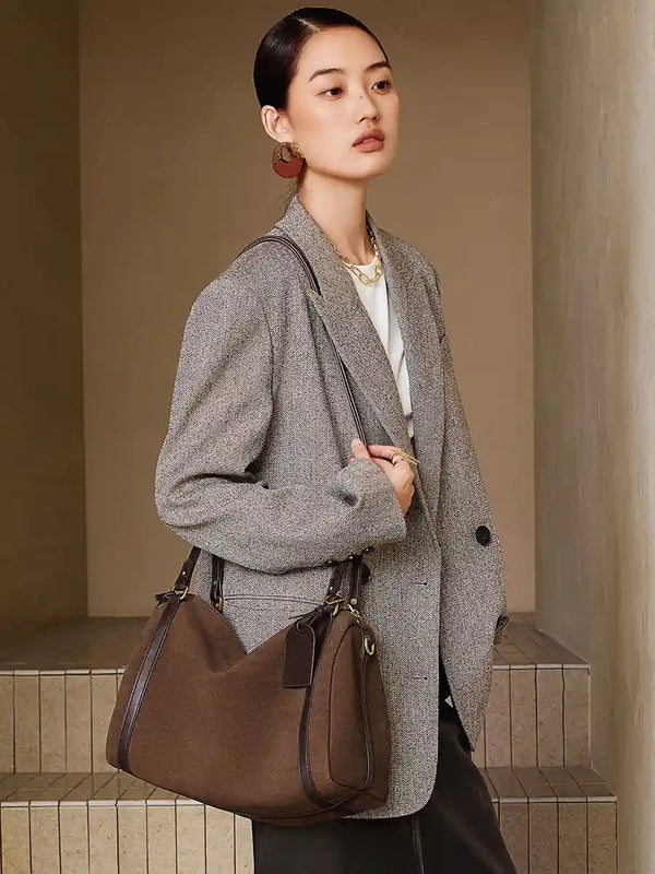 Model carrying a Suede Crescent Shoulder Bag, showcasing its vintage-inspired design and modern silhouette.