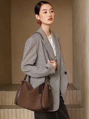 Model carrying a Suede Crescent Shoulder Bag, showcasing its vintage-inspired design and modern silhouette.