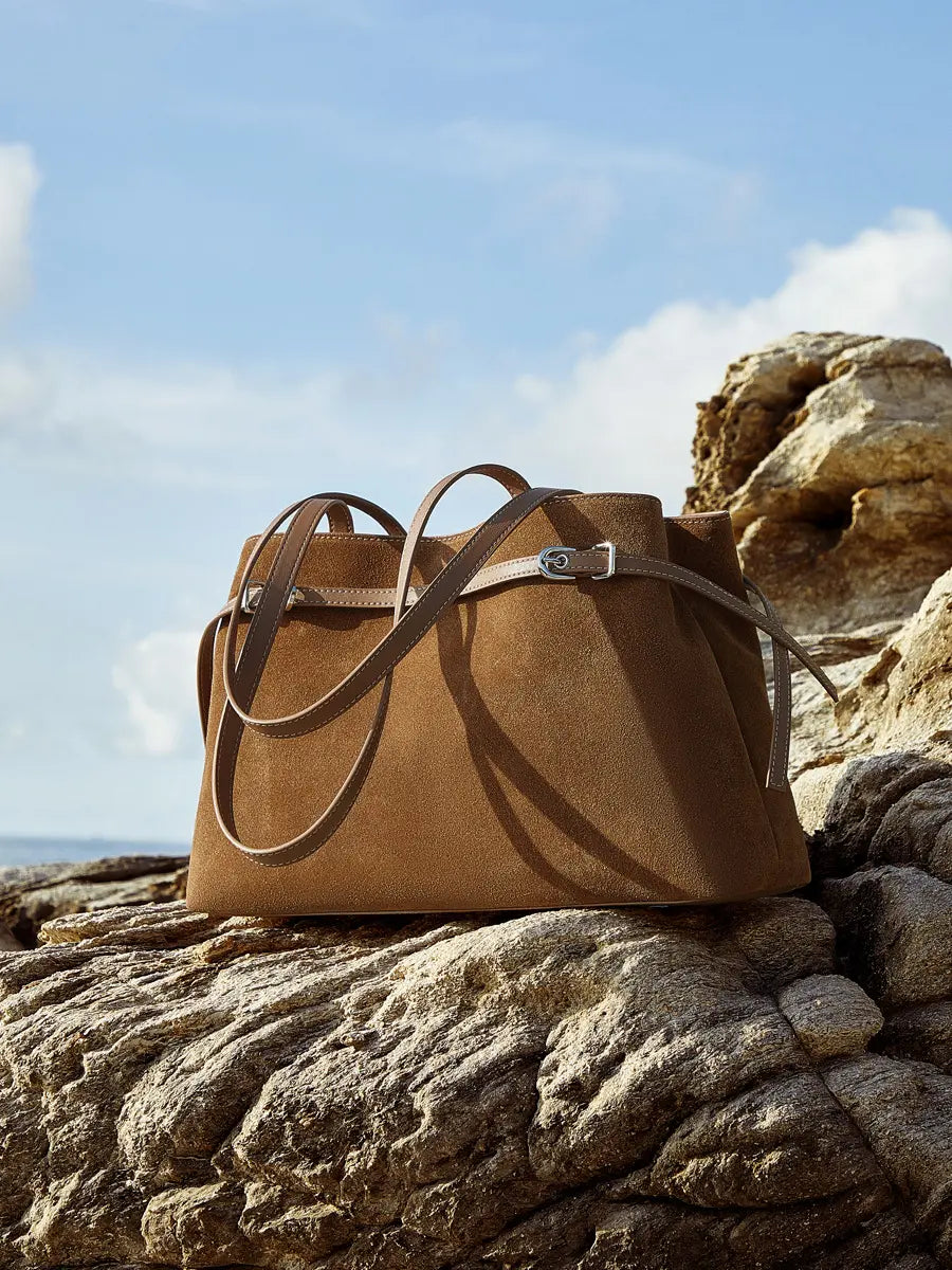 Suede Leather Baguette Shoulder Bag in brown on rocky terrain with adjustable strap for versatile styling.