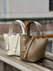 Classic Leather Bucket Bag in neutral tones, women's bucket bag with minimalist design, top-handle, lifestyle shot.