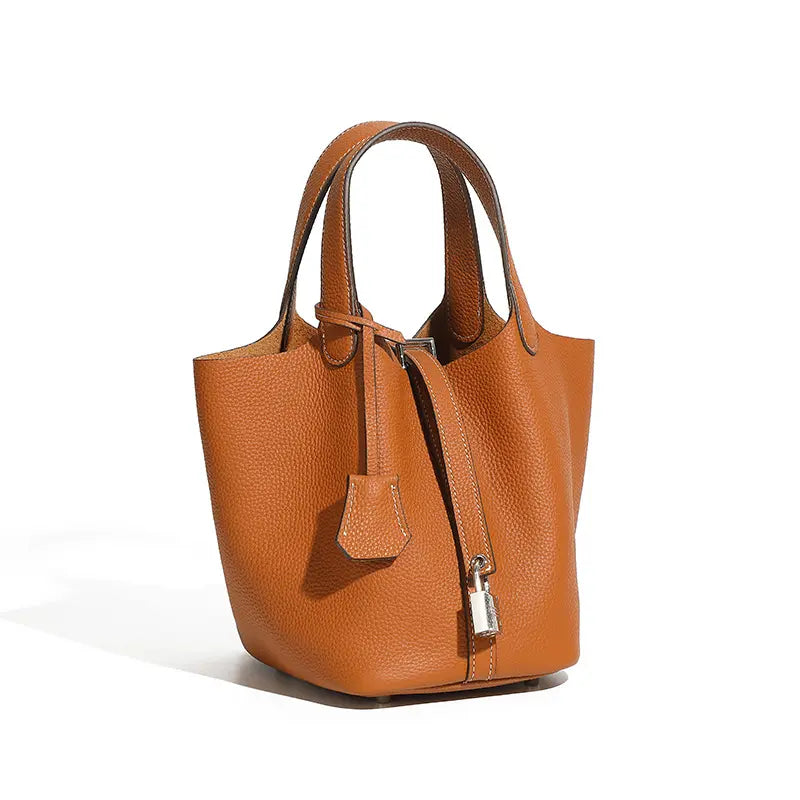 Classic Leather Bucket Bag in warm neutral tone, showcasing top-handle and drawstring design, perfect for everyday style.